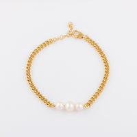 Overhead shpot of OAT's gold Vermeil Bracelet with Three Freshwater Pearls. The bracelet is aginst a plane white background and the pearls are reflecting light beautifully.