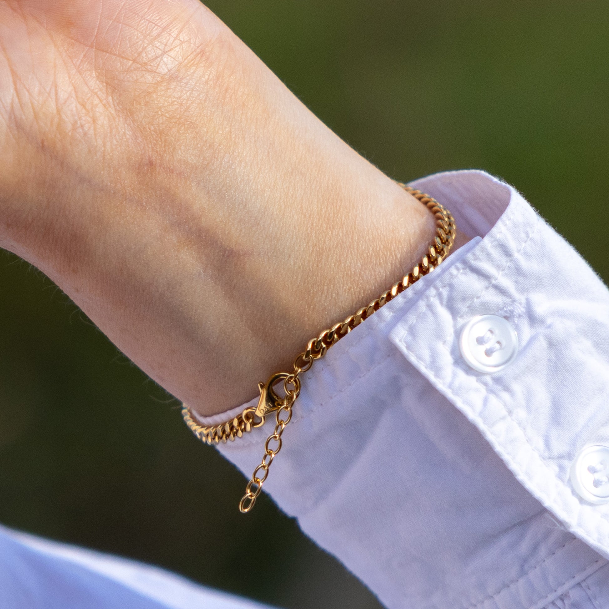 Close up shot of OAT Jewellerys gold Vermeil Bracelet with Three Freshwater Pearls. The close up shows the lobster clasp aginst the back of the models wrist