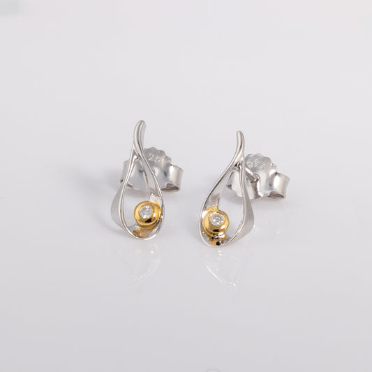 Stud earrings with a butterfly clasp. the earring is rhodium plated silver with gold vermeil detail surrounding one set diamond.