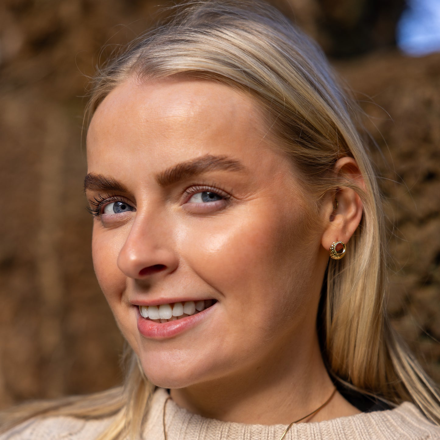 Model wearing Gold Vermeil Circle Stud Earrings with White Cubic Zirconia. The earring shave a textured finish that sparkles in the light