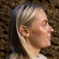 Side angle of model wearing OAT Jewellerys Gold Vermeil Circle Stud Earrings with White Cubic Zirconia. Nickle free and hypoallergenic earrings, suitable for sensitive ears