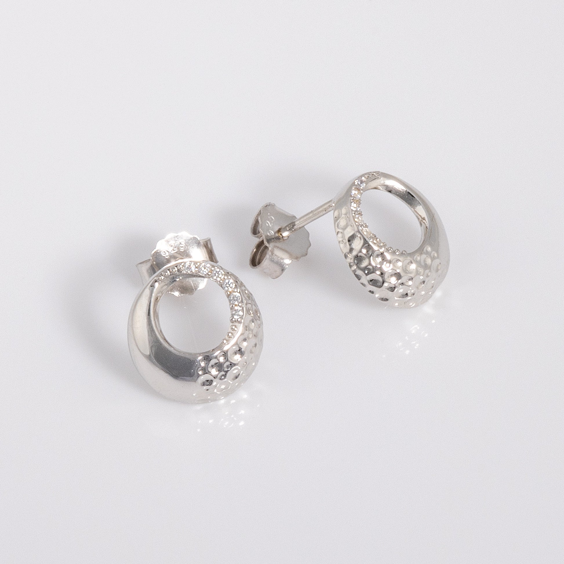 Rhodium plated silver Circle Stud Earrings with White Cubic Zirconia with a textured surface. The earrings have a butterfly back and are hypoallergenic suitable for all skin types.