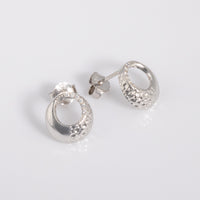 Rhodium plated silver Circle Stud Earrings with White Cubic Zirconia with a textured surface. The earrings have a butterfly back and are hypoallergenic suitable for all skin types.