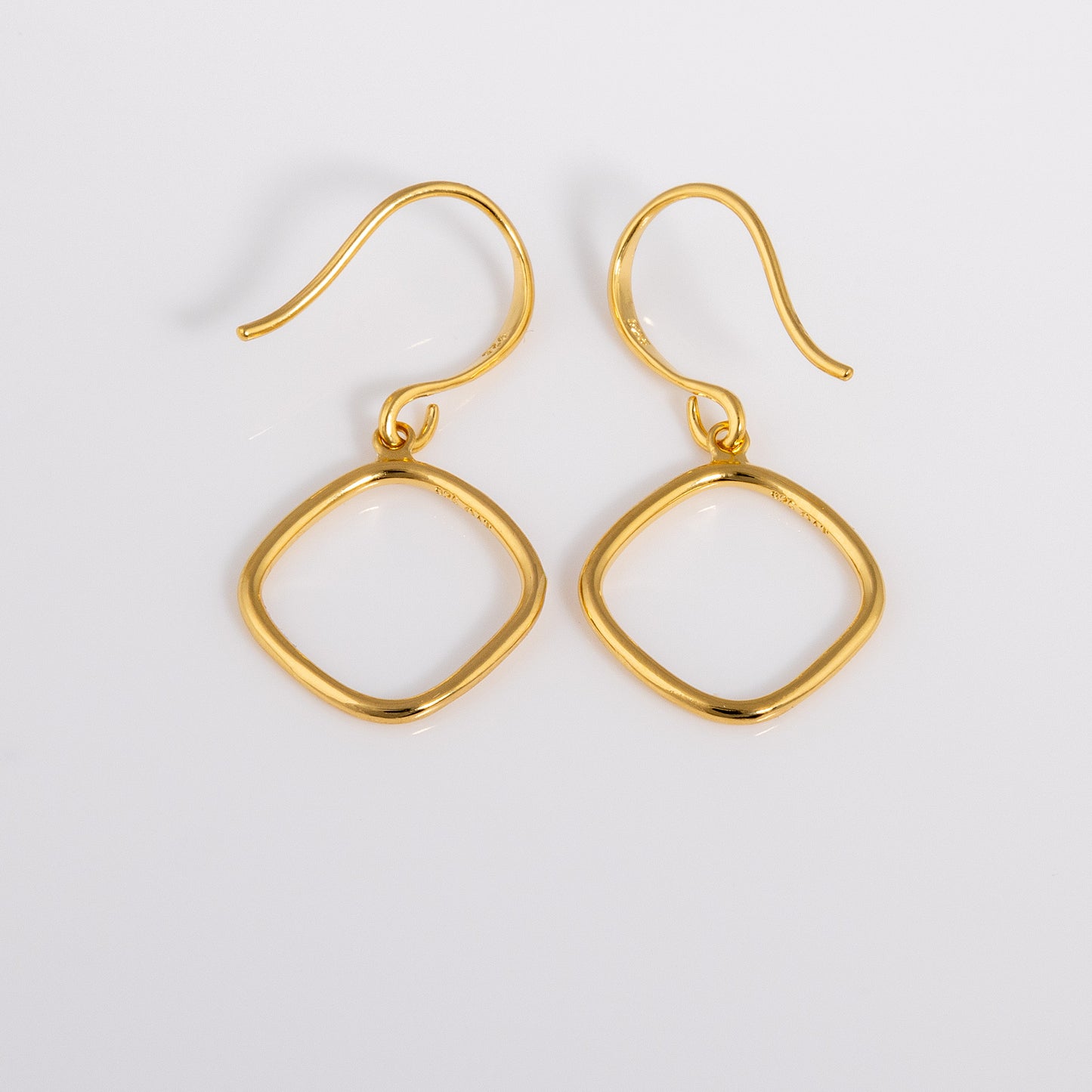 Close up shot of Simple Gold Vermeil Hook Earrings. Hypoallergenic earrings that have a hanging geometric ring shape.