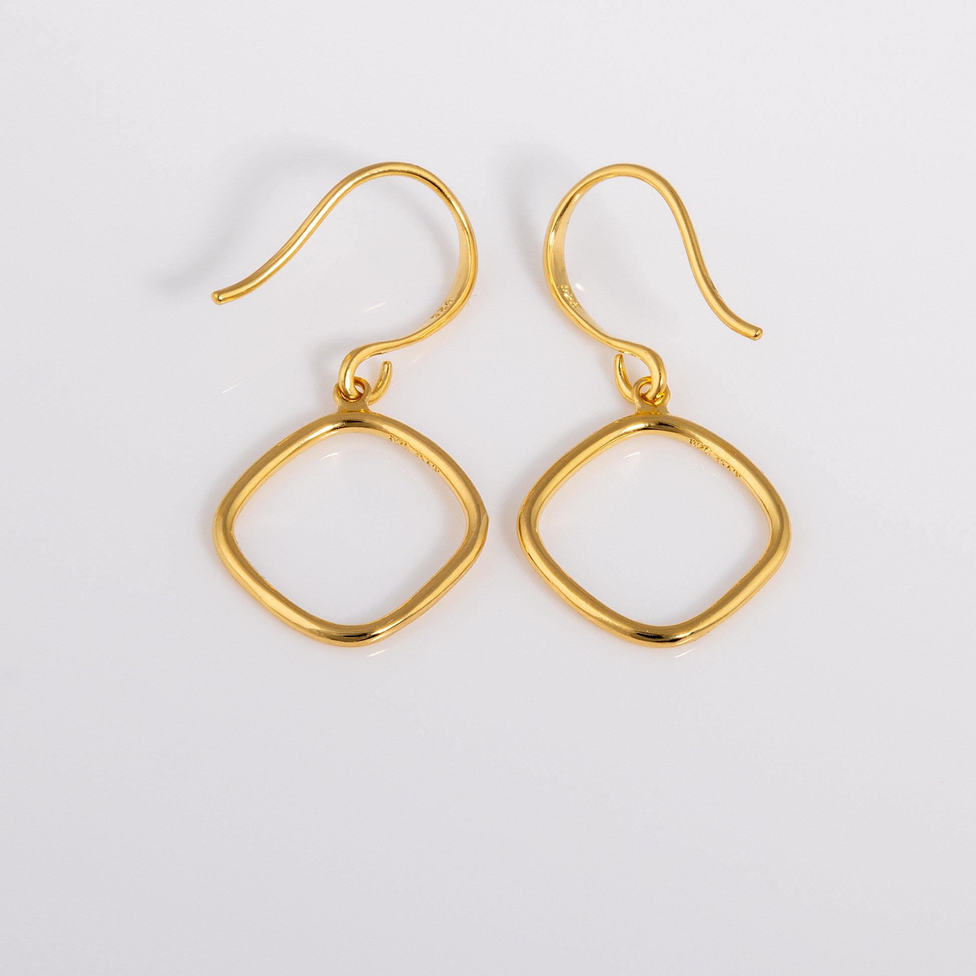 Close up shot of Simple Gold Vermeil Hook Earrings. Hypoallergenic earrings that have a hanging geometric ring shape.