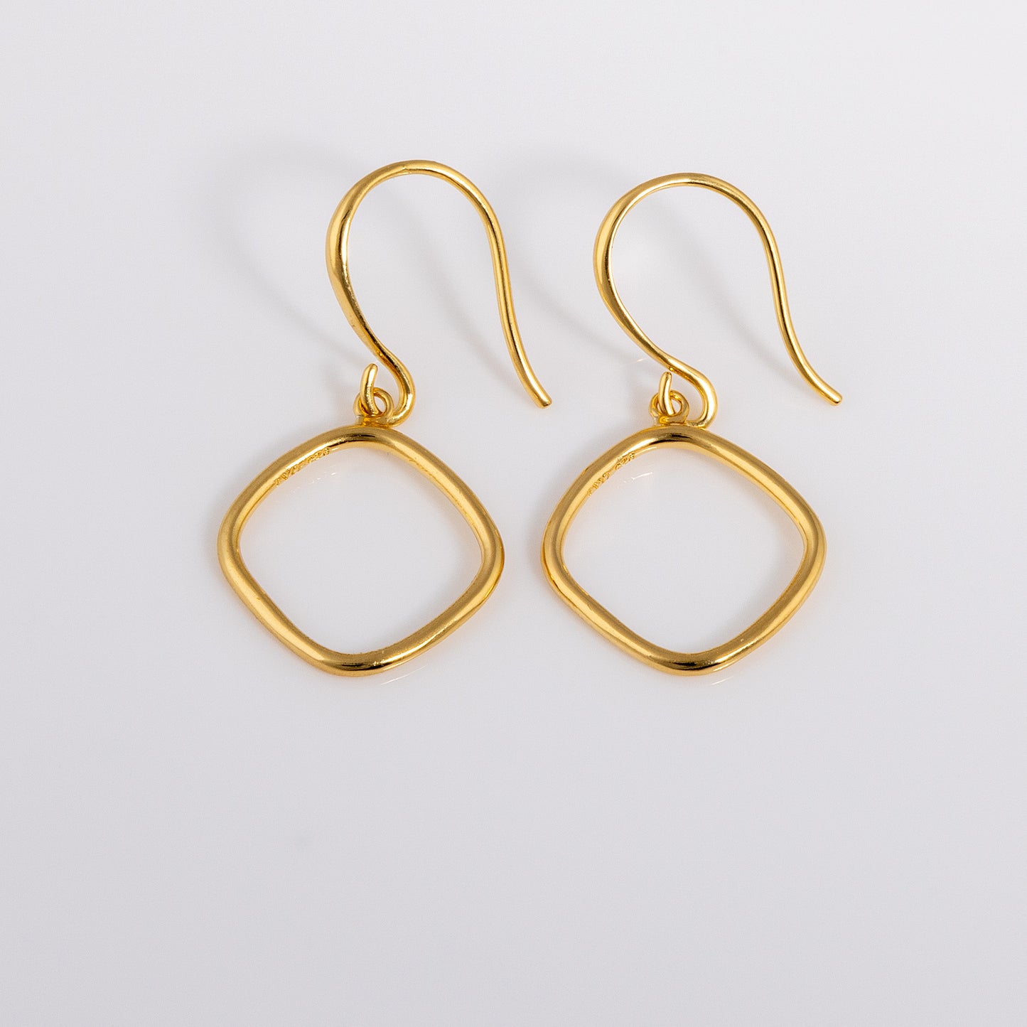 Simple and dainty Gold Vermeil Hook Earrings. They feature a hanging geometric ring.