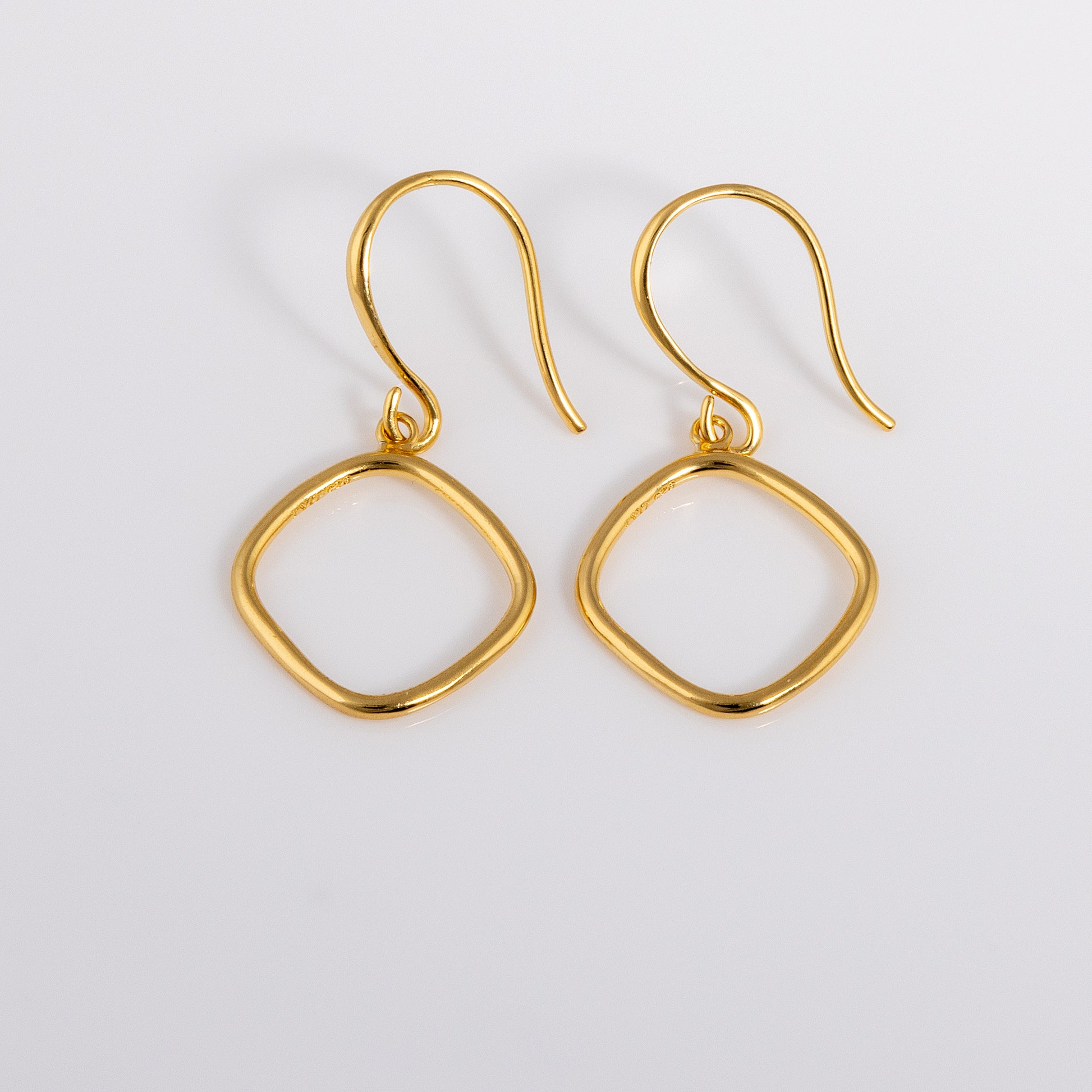 Simple and dainty Gold Vermeil Hook Earrings. They feature a hanging geometric ring.