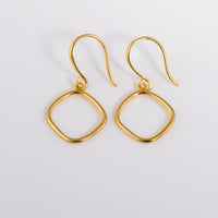 Simple and dainty Gold Vermeil Hook Earrings. They feature a hanging geometric ring.