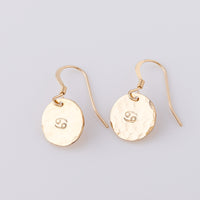 Fish hook, star sign earrings hand made from 14ct gold-fill. They have a hammered disc stamped with the cancer star sign stamped in the centre.