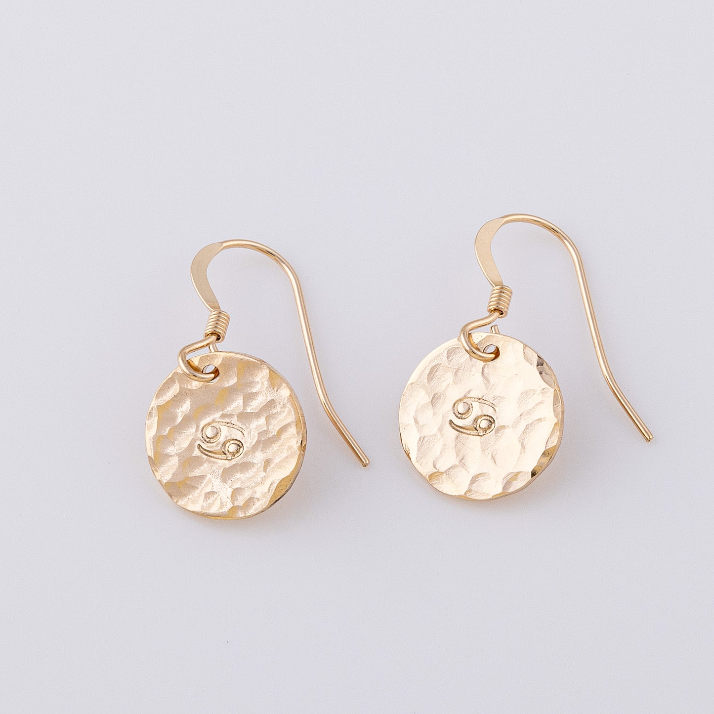 14ct gold-fill personalised disc earrings. Two fish hook earrings with a star sign stamped in the centre. They have a hammered, textured finish giving a lovely sparkle!