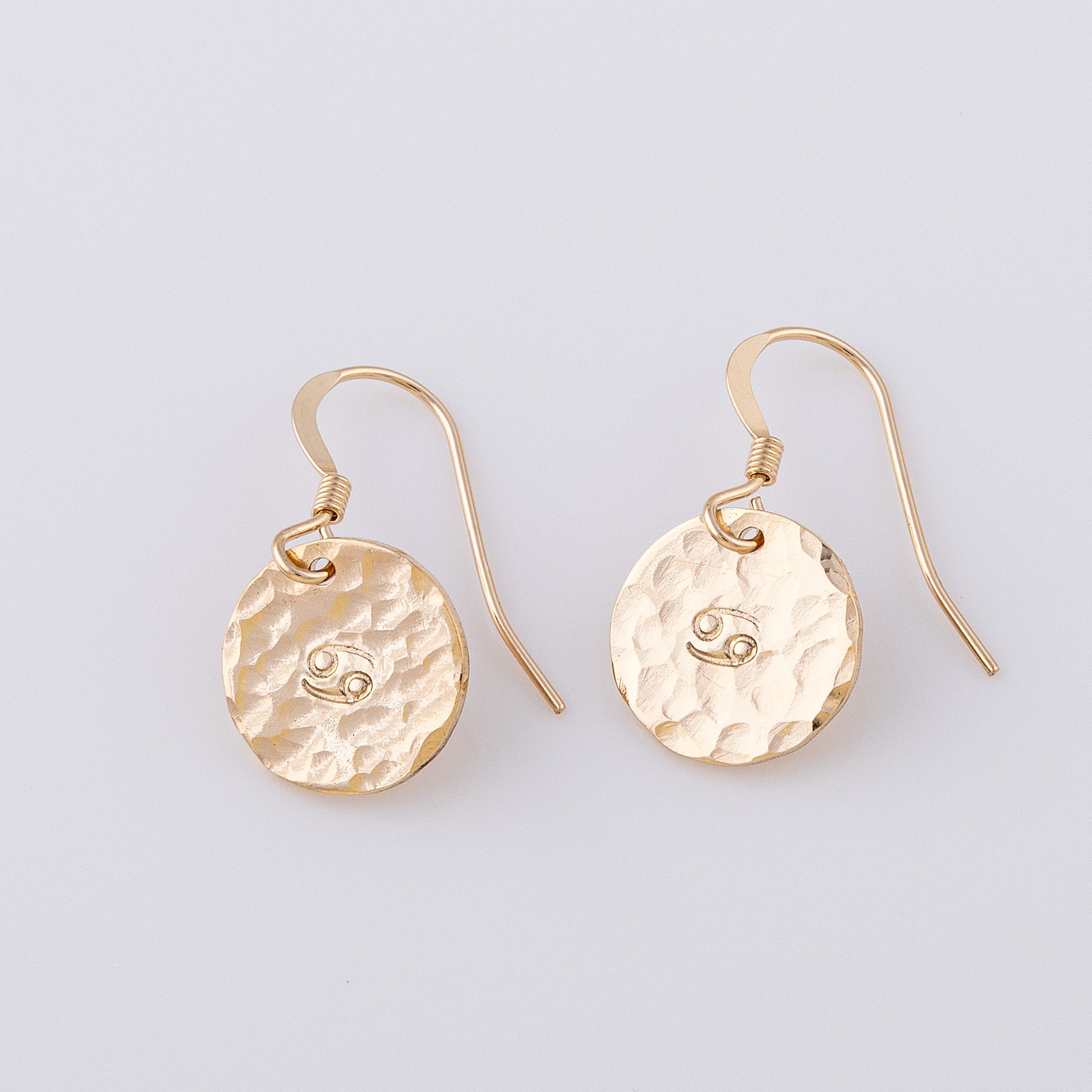 14ct gold-fill personalised disc earrings. Two fish hook earrings with a star sign stamped in the centre. They have a hammered, textured finish giving a lovely sparkle!