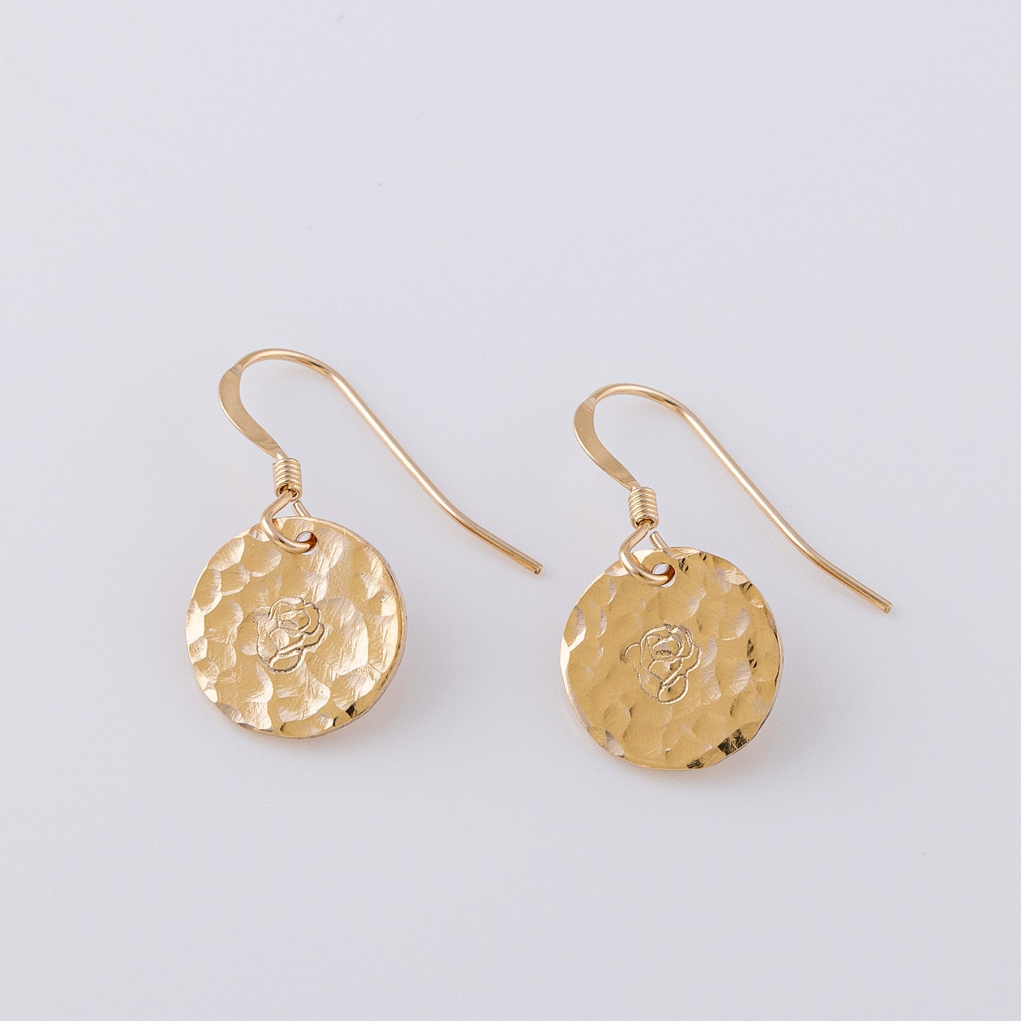 Two textured disc earrings. 14ct gold-fill, fish book earrings that are hand stamped with a rose/ birth flower. The discs are a textured finish, creating a lovely sparkle.