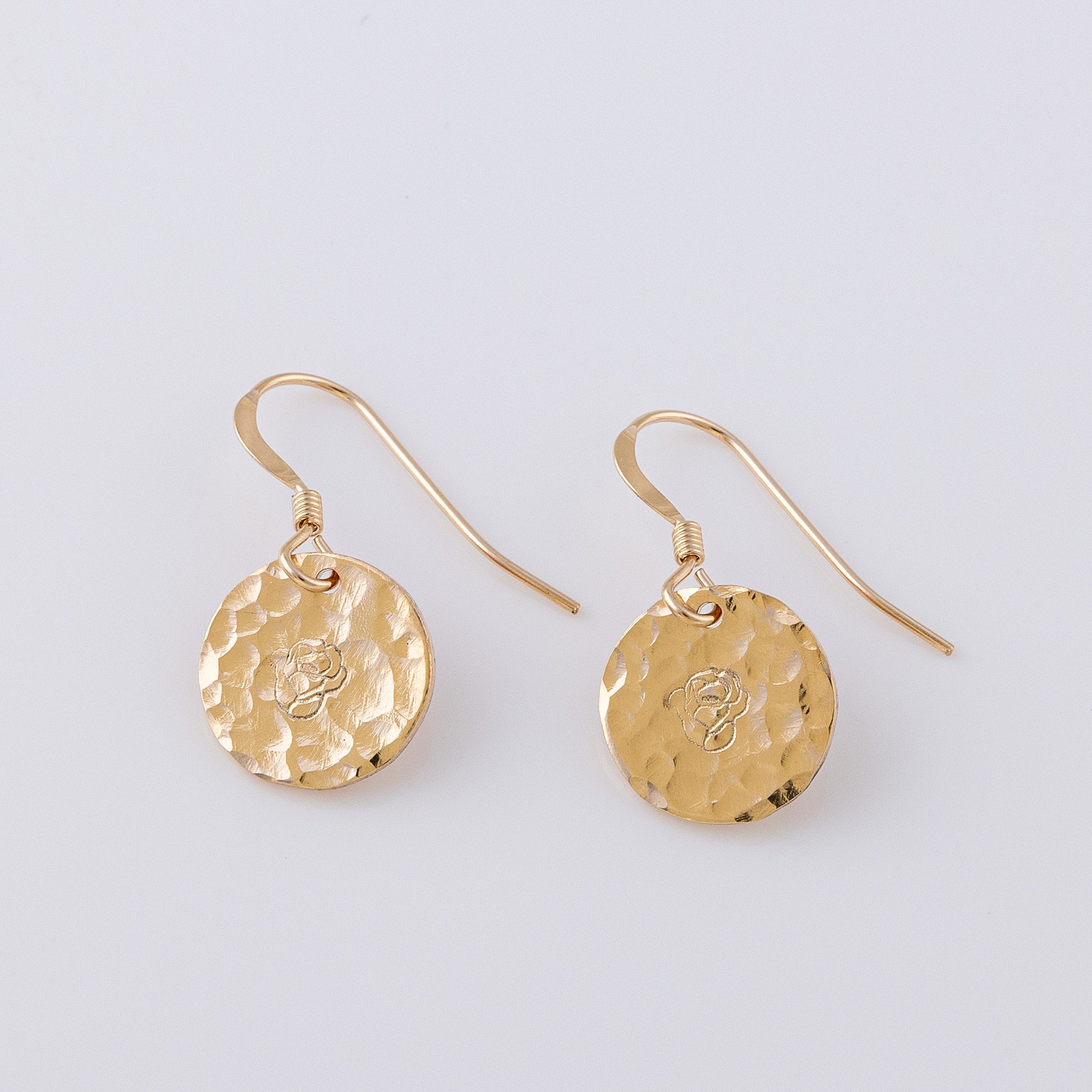 Two textured disc earrings. 14ct gold-fill, fish book earrings that are hand stamped with a rose/ birth flower. The discs are a textured finish, creating a lovely sparkle.