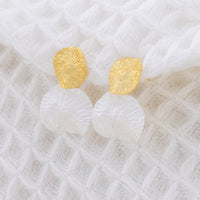 Textured, mixed metal, statement earrings. The earrings are two leaf like textured discs, stacked on each other. The top disc is gold vermeil while the buttom is rhodium plated silver
