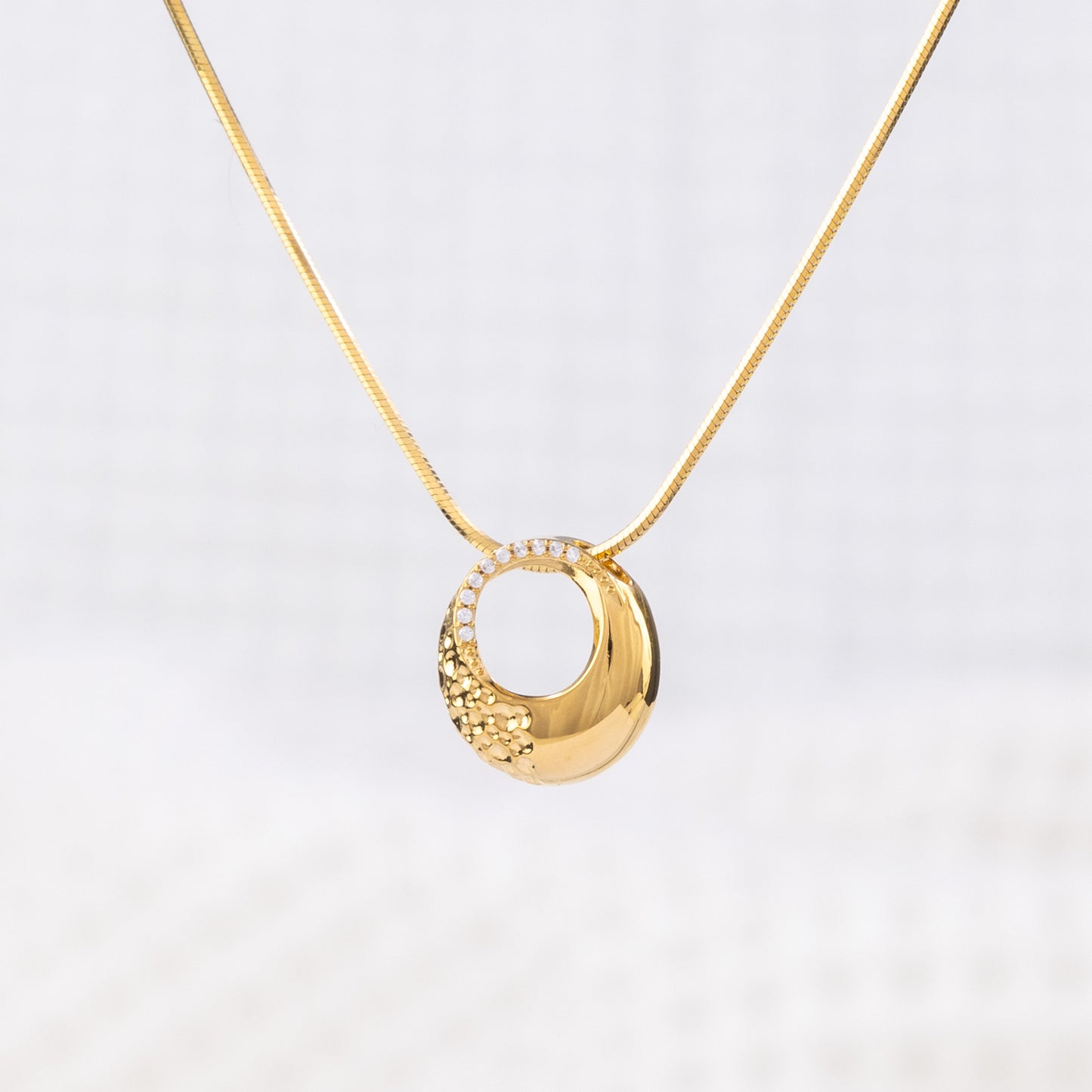 Classic appeal, gold Vermeil Circle Pendant Necklace with White Cubic Zirconia. A modern elegance, featuring a snake chain with a lobster clasp.