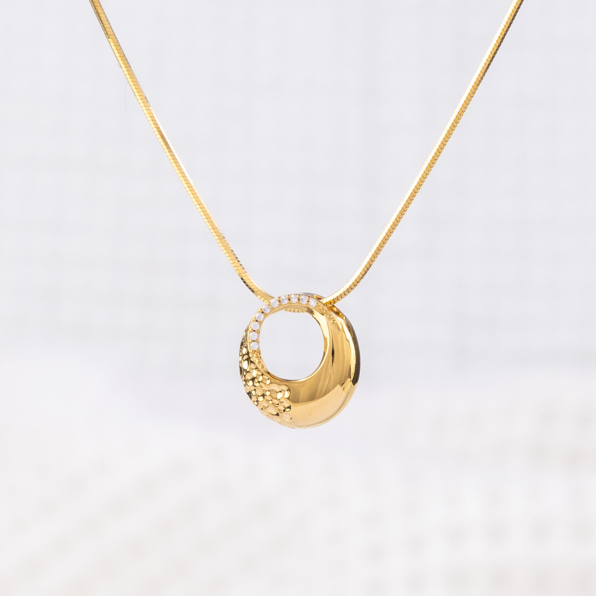 Classic appeal, gold Vermeil Circle Pendant Necklace with White Cubic Zirconia. A modern elegance, featuring a snake chain with a lobster clasp.