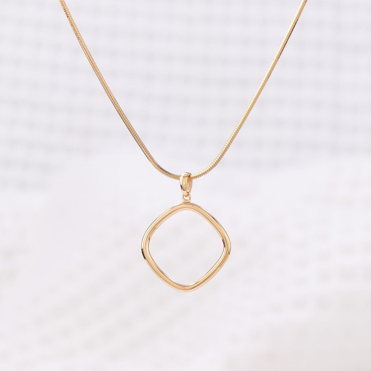 Simple Gold Vermeil Pendant Necklace. The pendant is a geometric shape with rounded edges.