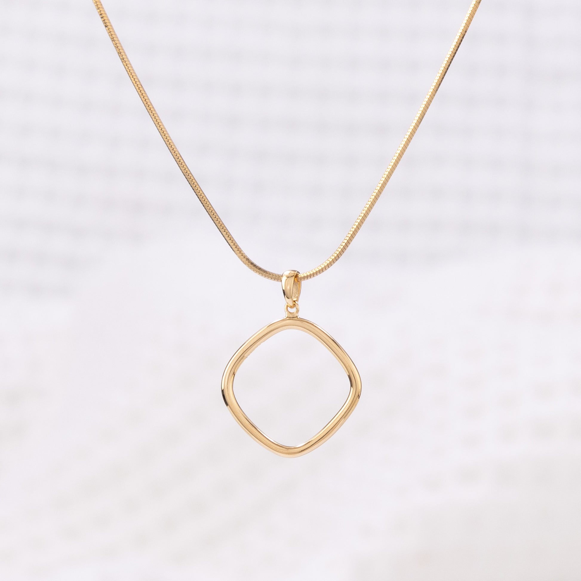 Simple Gold Vermeil Pendant Necklace. The pendant is a geometric shape with rounded edges.