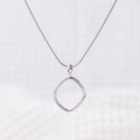 Simple Rhodium pkated silver Pendant Necklace. The silver reflects light and shines. The pendant hangs upon a snake chain