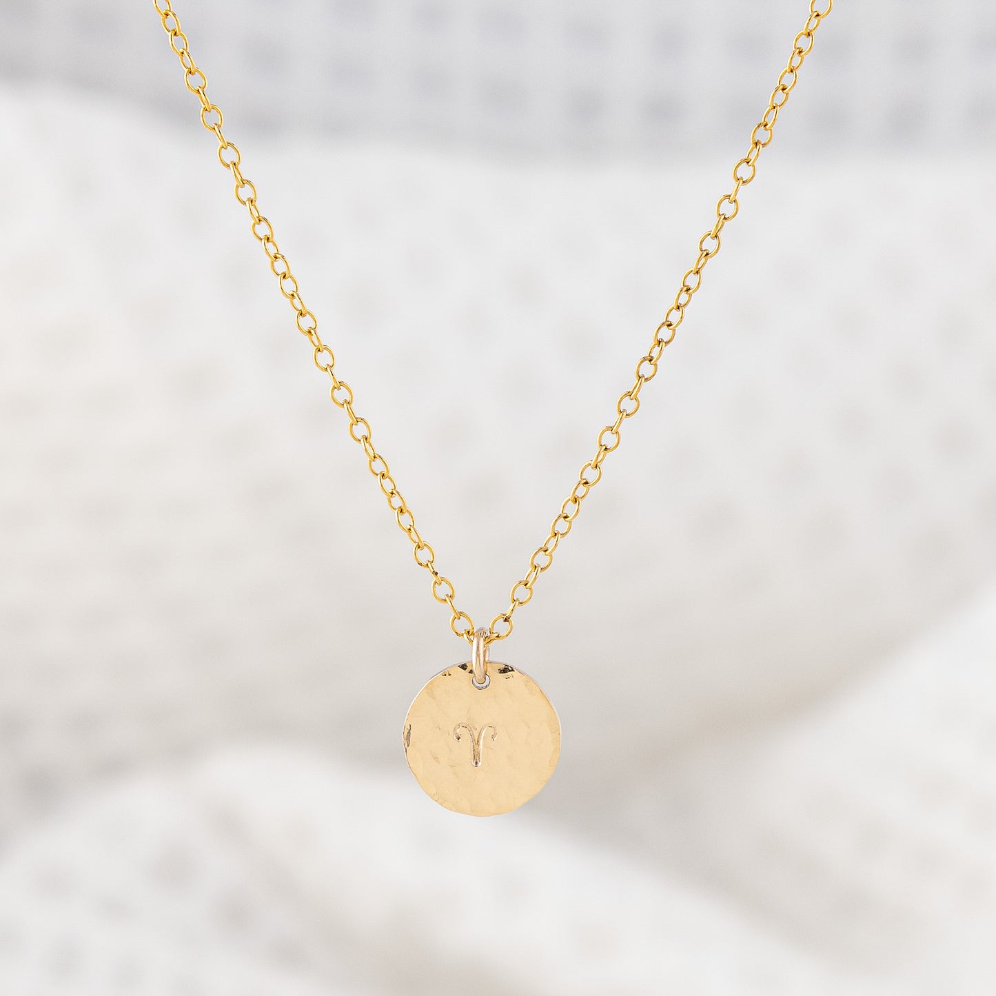 Personalsied star sign pendant necklace. OAT Jewellery's 14ct gold filled disc pendant. The disc is a hammered finish with a zodiac sign stamped in the center.
