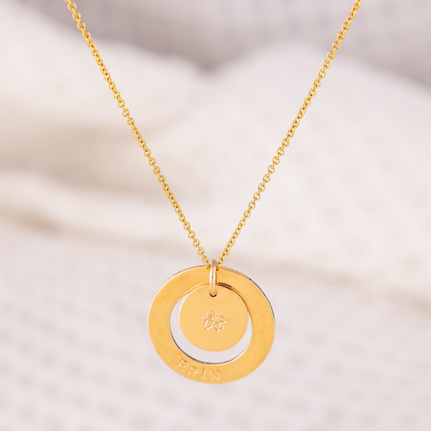Beautiful, personalised name necklace. The OAT Jewellery Dooey necklace is a beautiful 14ct gold-filled piece, tarnish resistant and hand stamped with your name! The pendant has a halo, where the name is stamped and a smaller disc inside, where a birth flower is stamped. The chain is lightweight and fine.