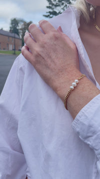Video clips of a gold Vermeil Bracelet with Three Freshwater Pearls making the centrepiece of the bracelet. The bracelet is being worn with a white long sleeve shirt!