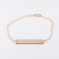 14ct gold-filled gold name bar bracelet. Smooth simple gold bar on a dainty chain with a lobster clasp. 