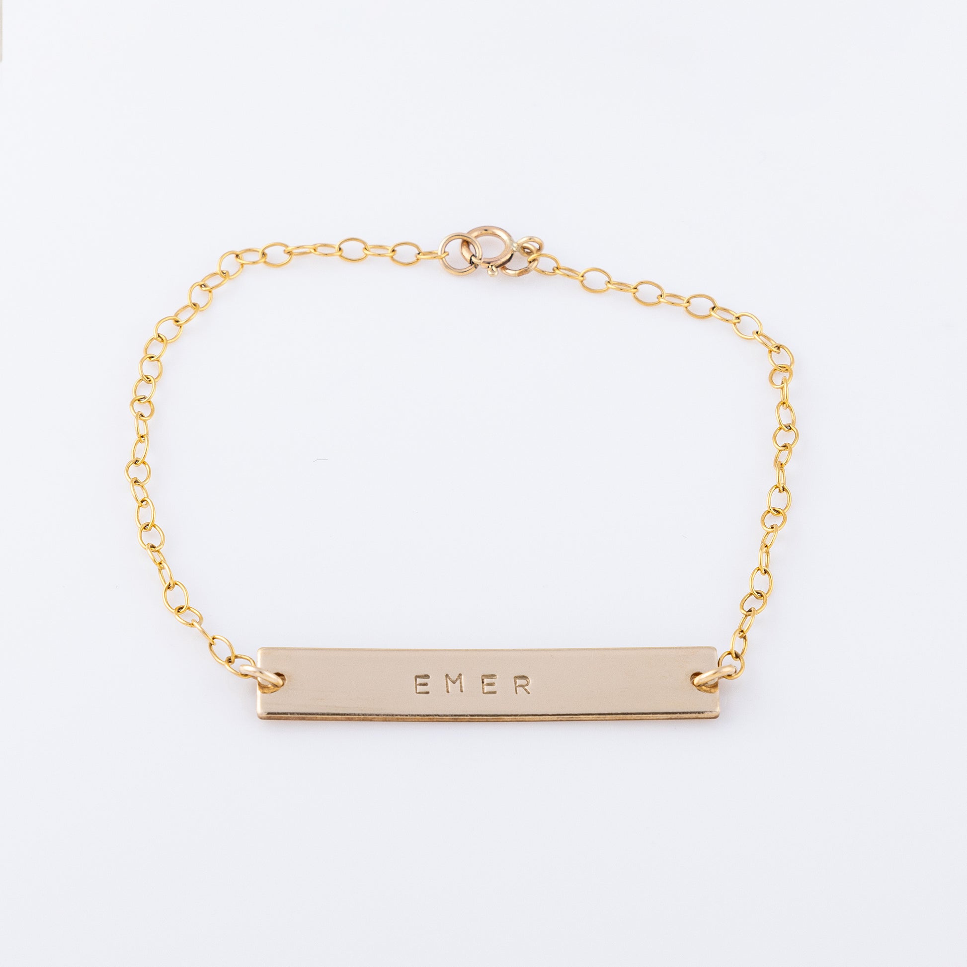 14ct gold-filled gold name bar bracelet. Smooth simple gold bar with name stamped across it on a dainty chain with a lobster clasp 
