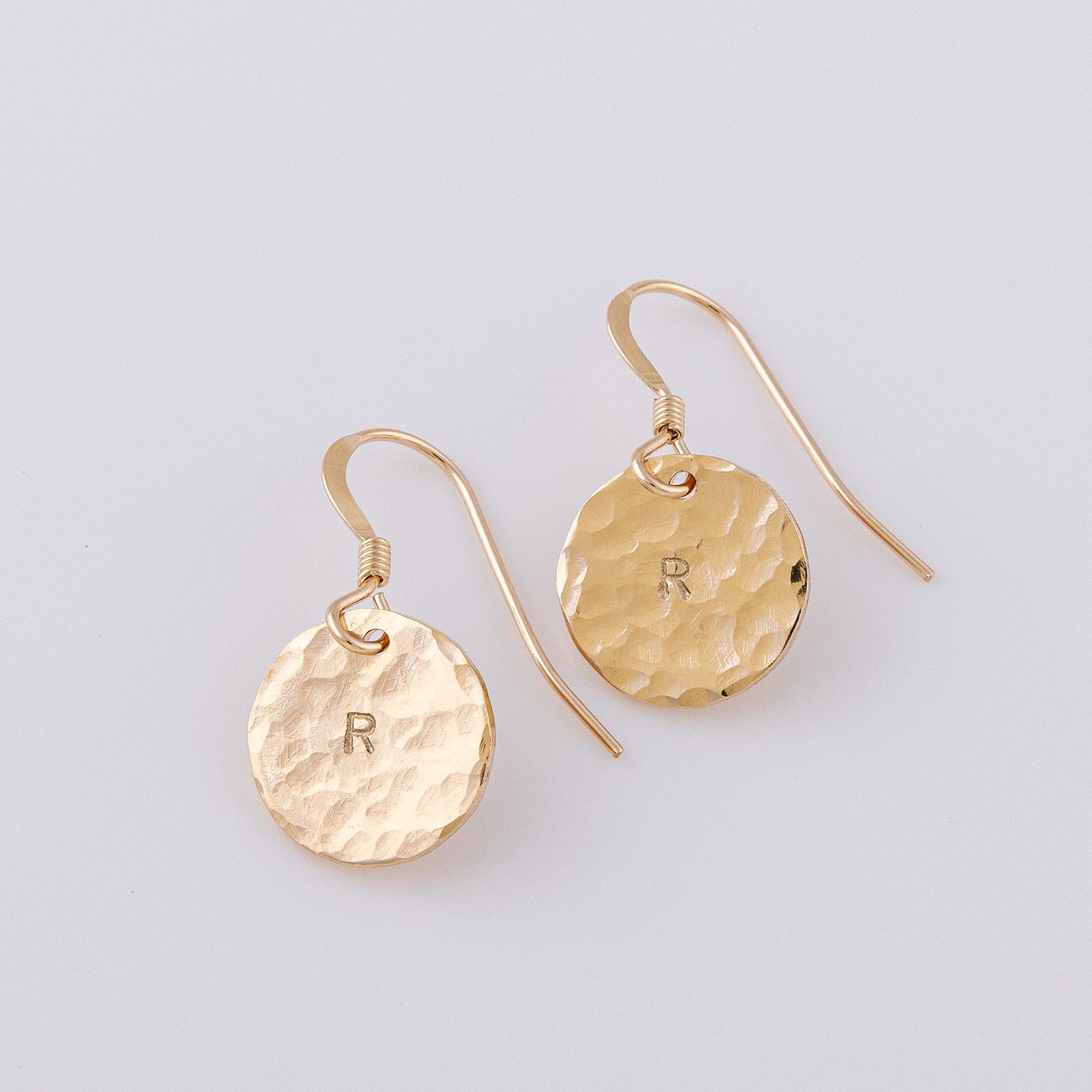 two fish hook, disc earrings. The disc is 14ct gold-fill and a hammered finish, giving them a beautiful sparkle. The earrings are stamped with an initial