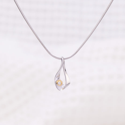 Rhodium plated silver, snake chain,  pendant necklace. The tear shaped pendant is rhodium plated silver with gold vermeil detail and a set diamond