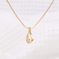 A gold vermeil pendant necklace, with a gold vermeil snake chain. The pendant is a tear drop shape with a set diamond detail. 