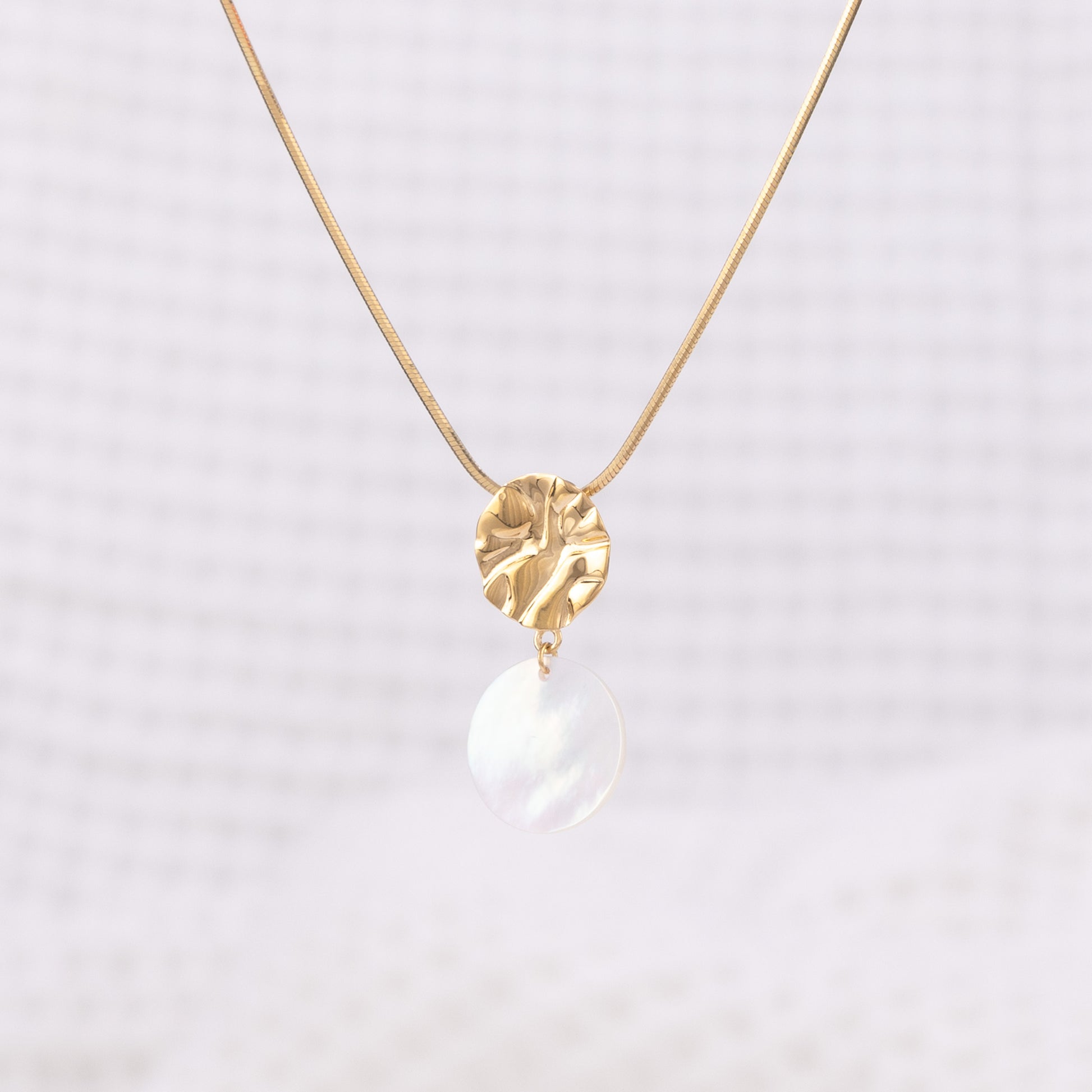 Molten design, Textured Gold Vermeil Pendant Necklace with Mother of Pearl Dangling. The pendant hangs on a snake chain