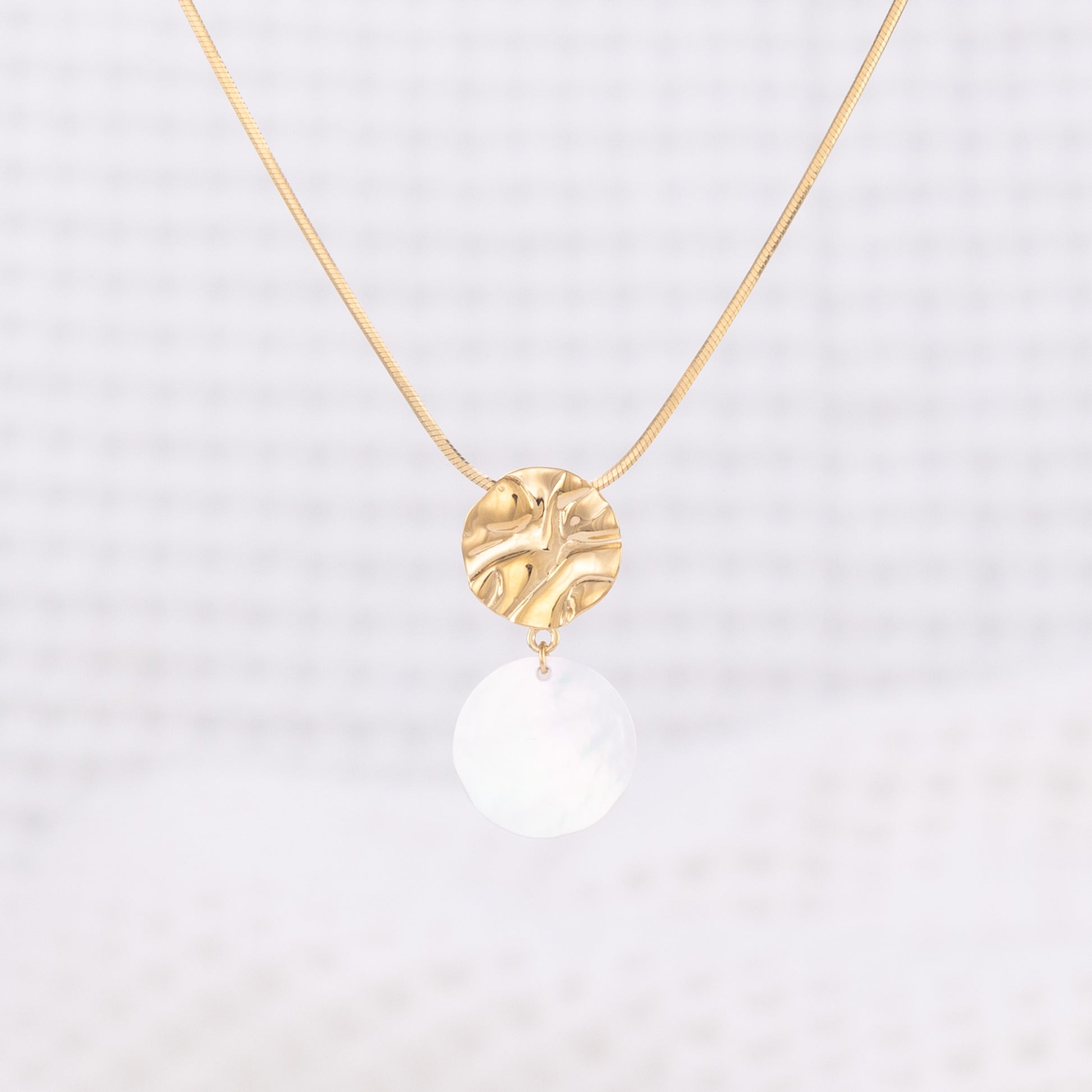 Textured, molten design, Gold Vermeil Pendant Necklace with a disc of Mother of Pearl Dangling. The pendant hangs on a snake chain thathas a lobster clasp