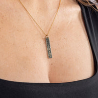 Model wearing a 14ct gold filled personalised, hammered bar pendant necklace. The pendant is handstamped with 'slainte' but it can be stamped with a custom word of your choice. The hammered texture creates a sparkle when it catches the light. Tarnish resistant and nickle free