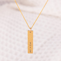 A personalsied 14ct gold fill necklace. The hammered bar pendant is hand stamped with a custom word of your choice. 