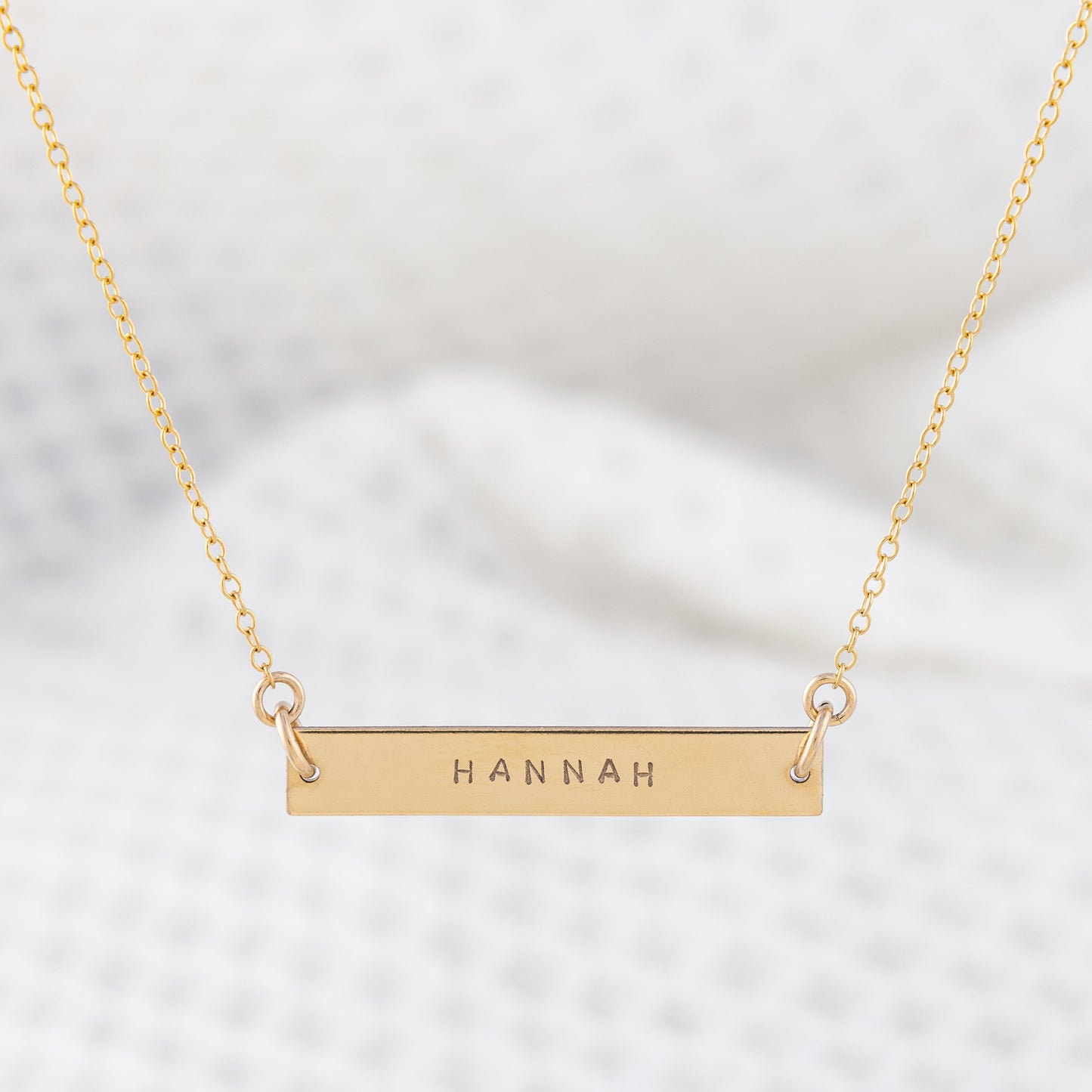 14ct gold-filled gold name bar necklace. A smooth, gold, bar pendant hand stamped with name on a fine gold chain