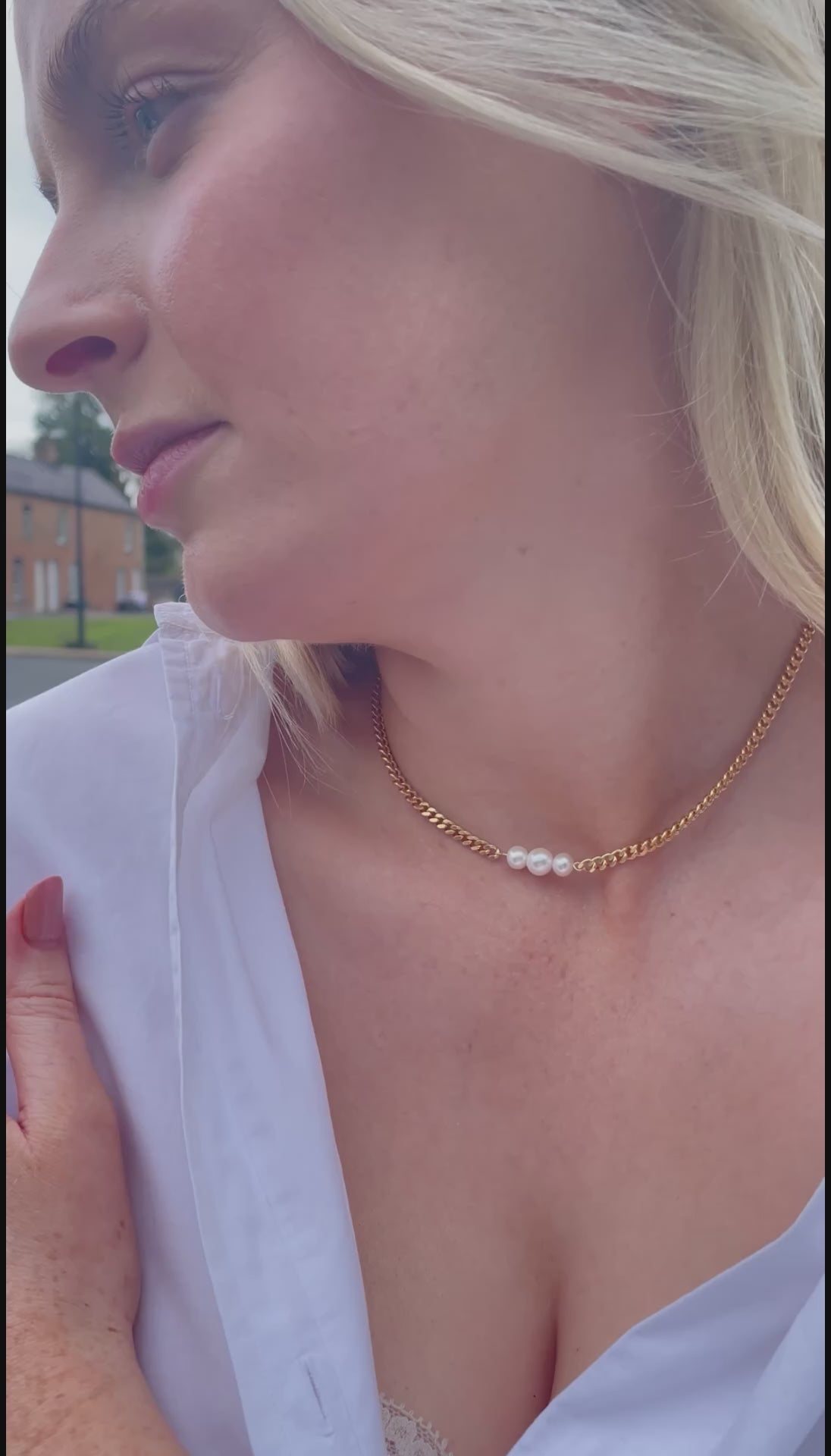 Video of model wearing a curb chain Gold Vermeil Necklace featuring three Freshwater Pearls as the necklaces centrepiece. The necklace is a choker style and styled with a white shirt. 