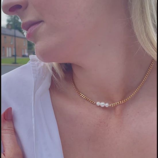 Video of model wearing a curb chain Gold Vermeil Necklace featuring three Freshwater Pearls as the necklaces centrepiece. The necklace is a choker style and styled with a white shirt. 