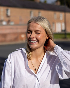 Roisín wearing our Rainer gold vermeil necklace outside the Red Row in Mullan Village.